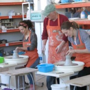 Un grupo de personas crea piezas en un taller de cerámica artística, demostrando creatividad y trabajo en equipo