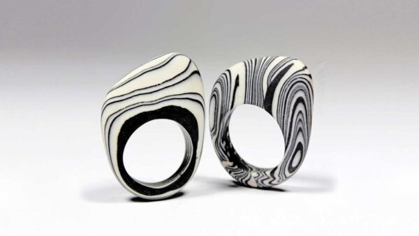 Anillos que hacen parte de una colección de joyas de diseño de autor en cerámica, con líneas a blanco y negro