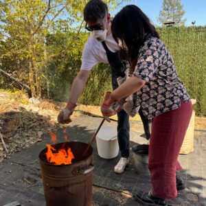 2 personas horneando piezas con la tecnica del Raku