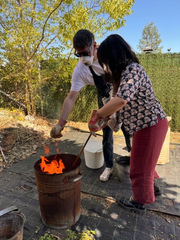 2 personas horneando piezas con la tecnica del Raku