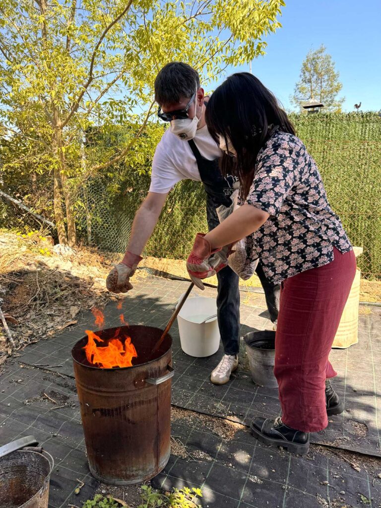 Un hombre y una mujer cocen cuidadosamente piezas de arcilla en un horno para barro y cerámica de forma ancestral