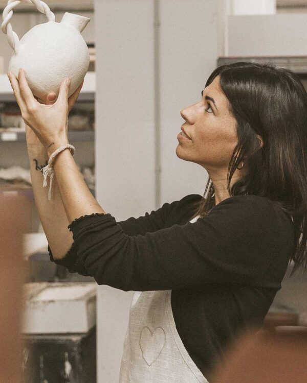 Mujer sosteniendo una jarra de cerámica artesanal