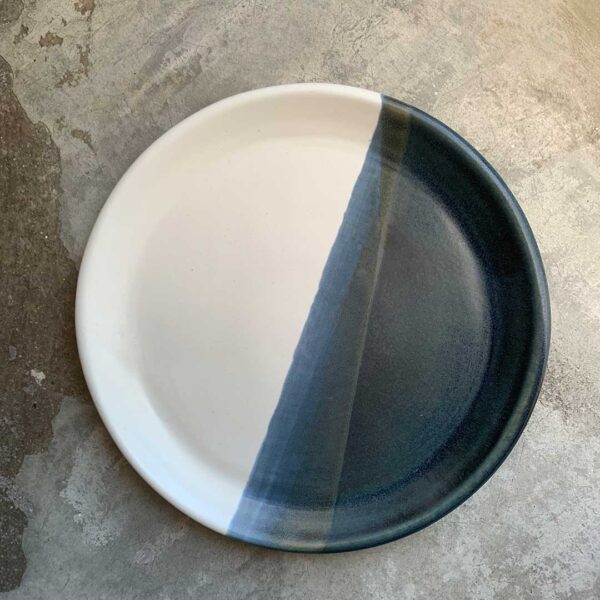 Plato artesanal de barro con diseño de rayas blancas y azules